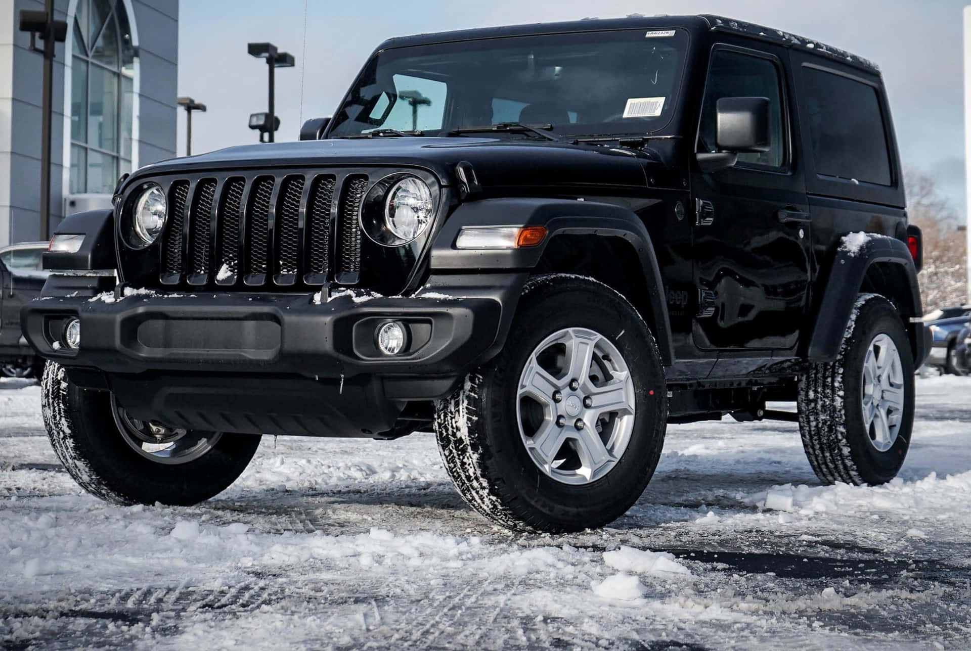 冬季停在雪地上的黑色Jeep Wrangler。