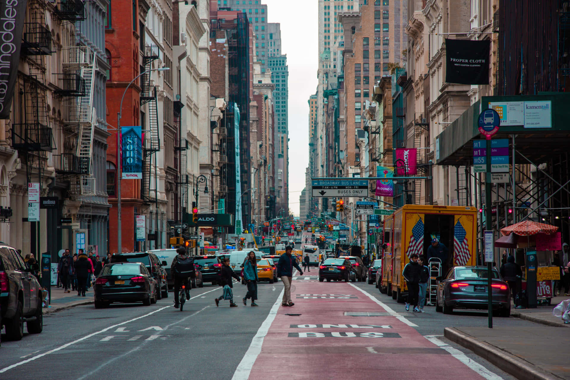 繁忙的城市街道，高樓之間有行人和車輛。