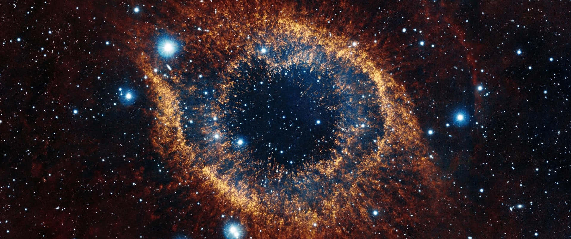 在深空中帶有橙色和藍色色調的發光眼形星雲。