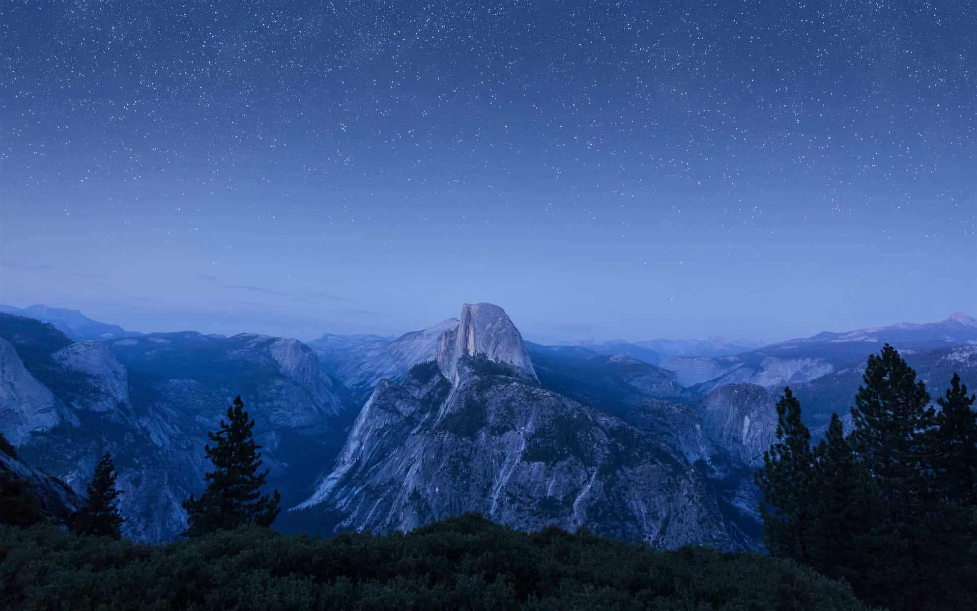 半圓頂山在星空下，前景有松樹