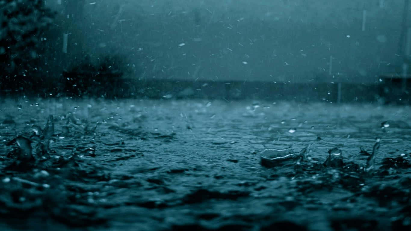 在暴風雨的天空下，雨滴在潮濕的地面上濺起的特寫。