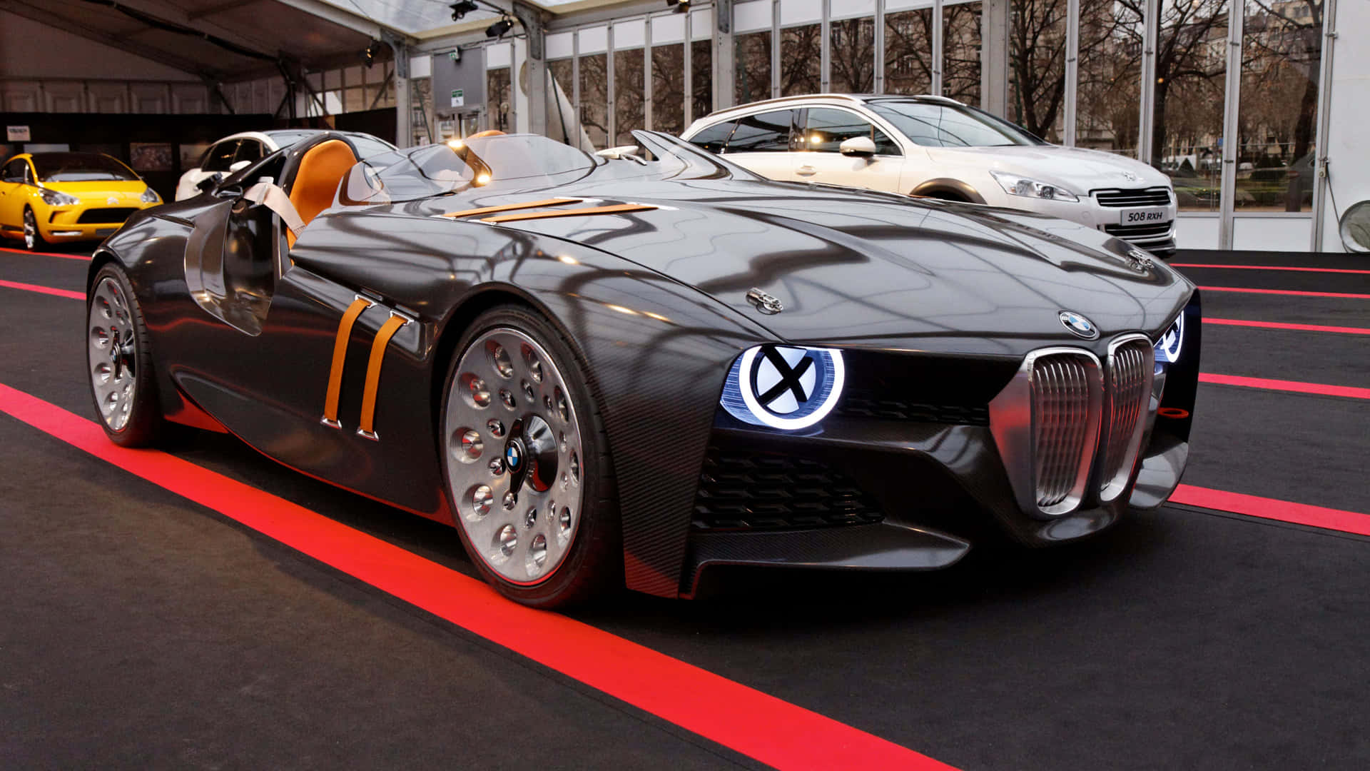 黑色BMW概念車，帶有橙色裝飾和發光車頭燈展出。