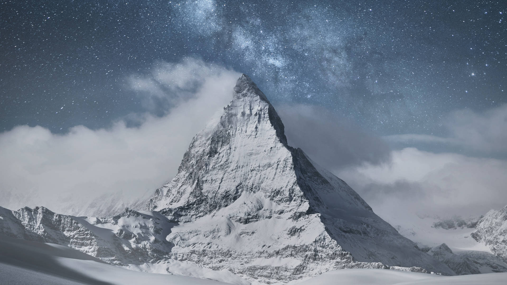 在繁星點點的夜空下，白雪覆蓋的山峰，銀河可見。