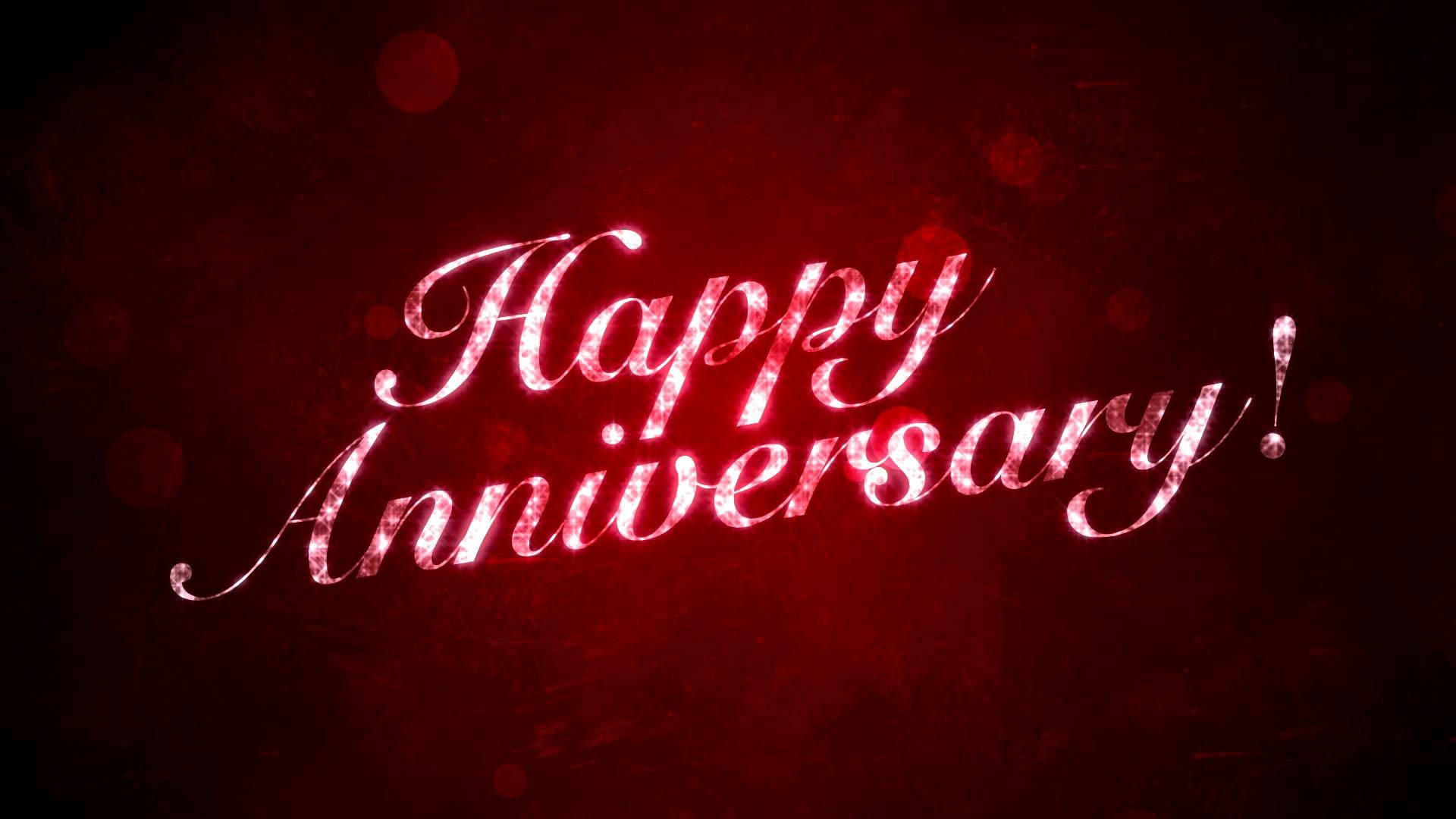深色背景上帶有柔和散景燈光和發光紅色草書的Happy Anniversary文字