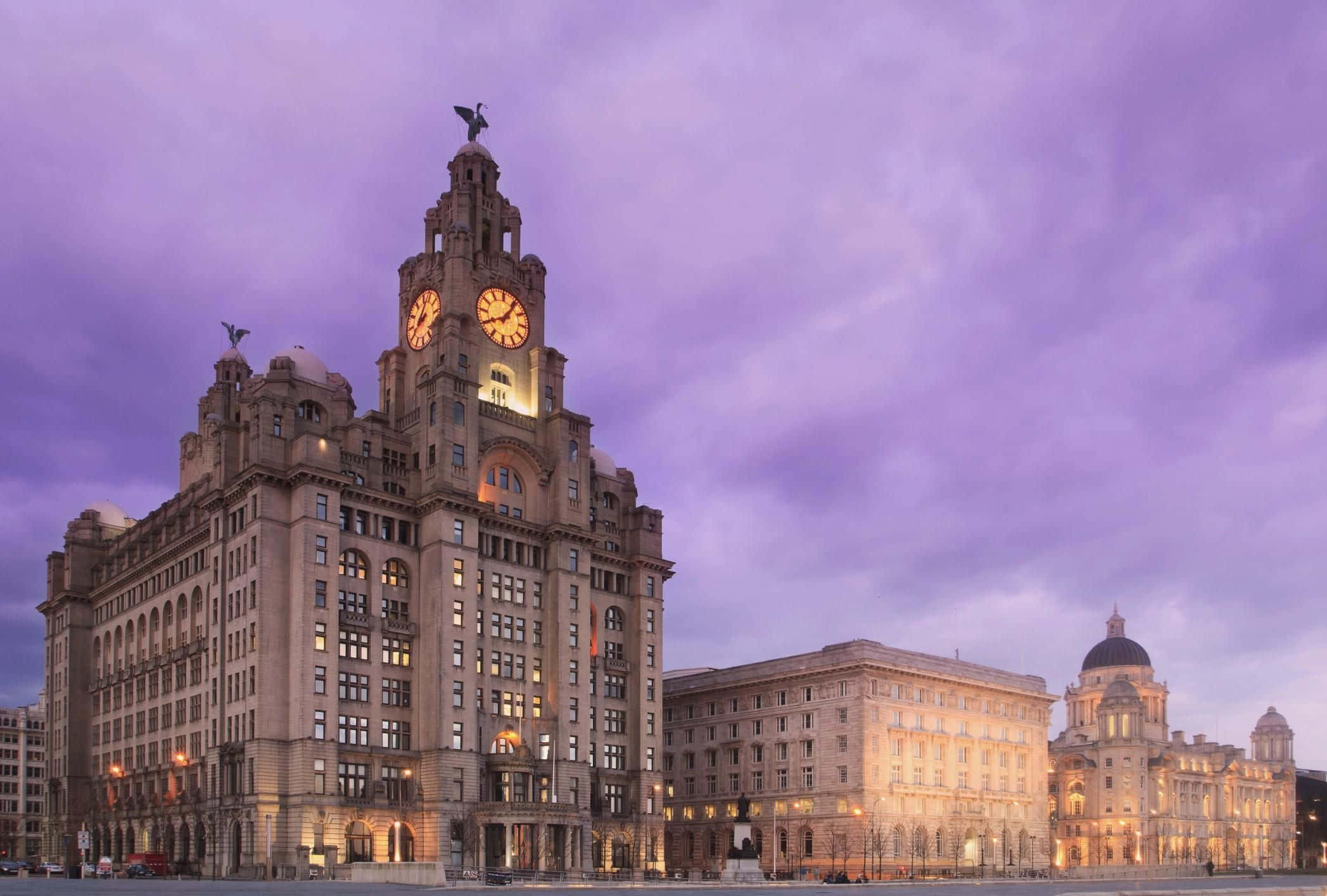 歡迎來到利物浦——英國足球之都 壁紙 — Grand Liver Building 在紫色暮色天空下亮起，發光的鐘面和華麗的建築。