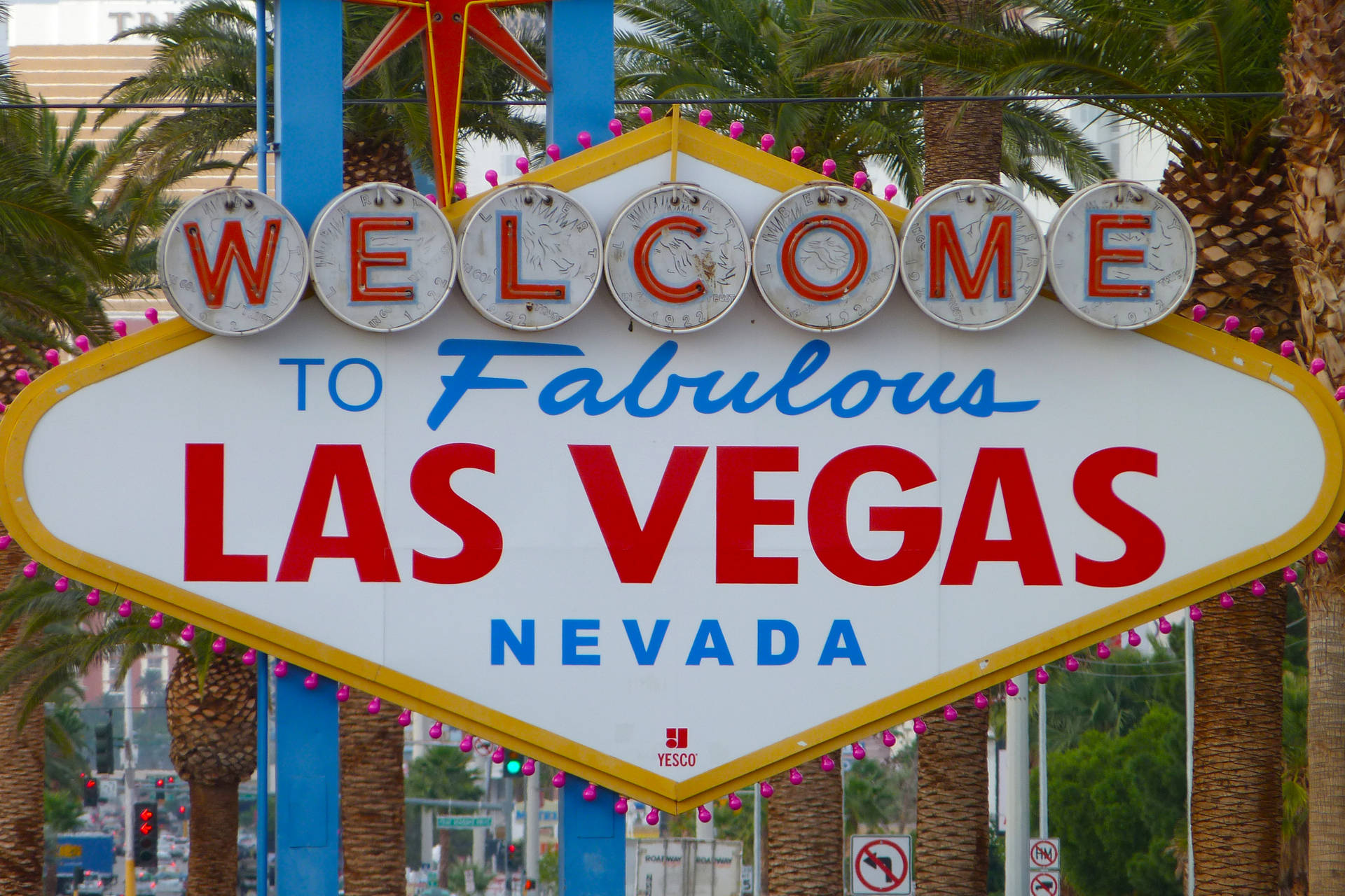 歡迎來到 Fabulous Las Vegas Nevada 標誌，背景有棕櫚樹和城市交通。
