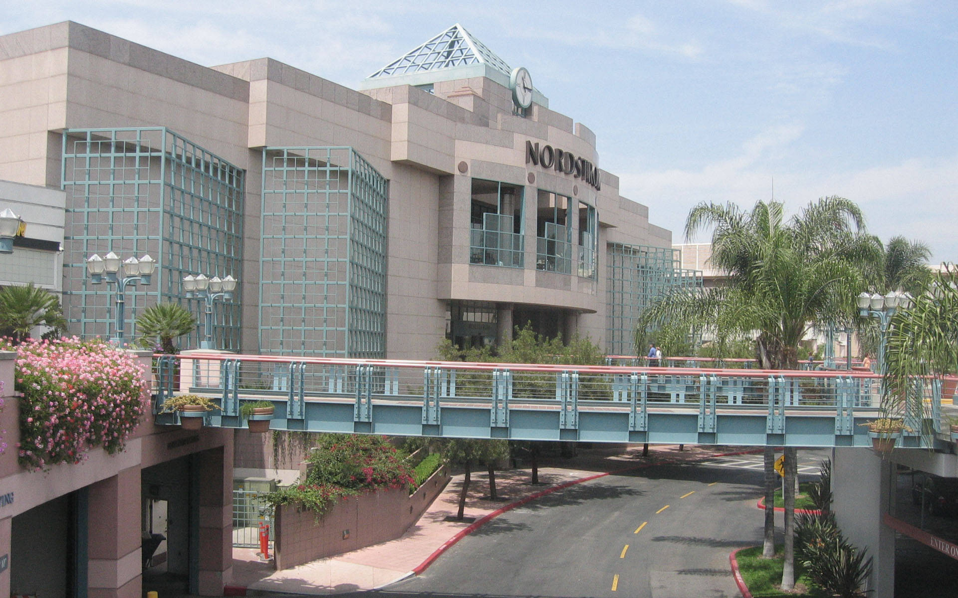 Nordstrom建築，設有行人天橋和棕櫚樹，在藍天下。