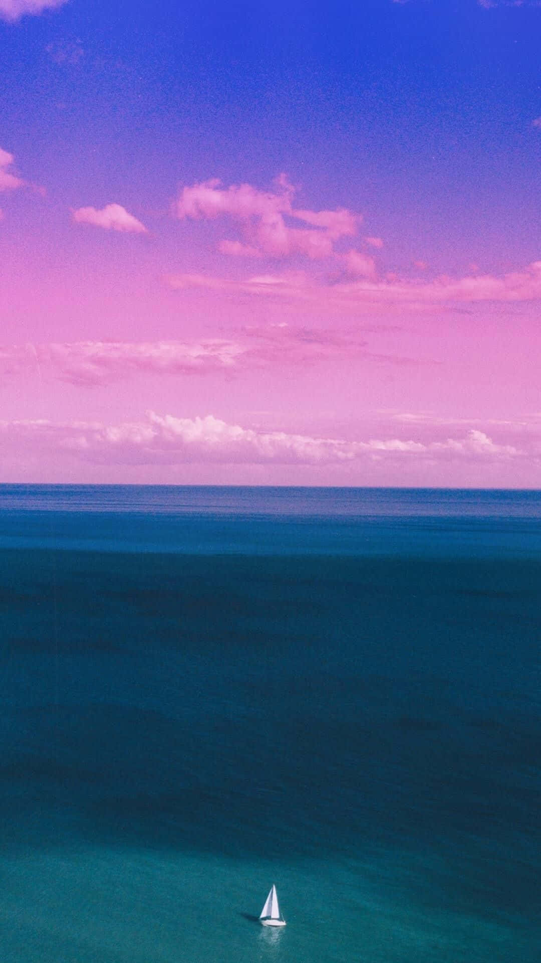 帆船在平靜的海面上，天空是粉紅色和藍色