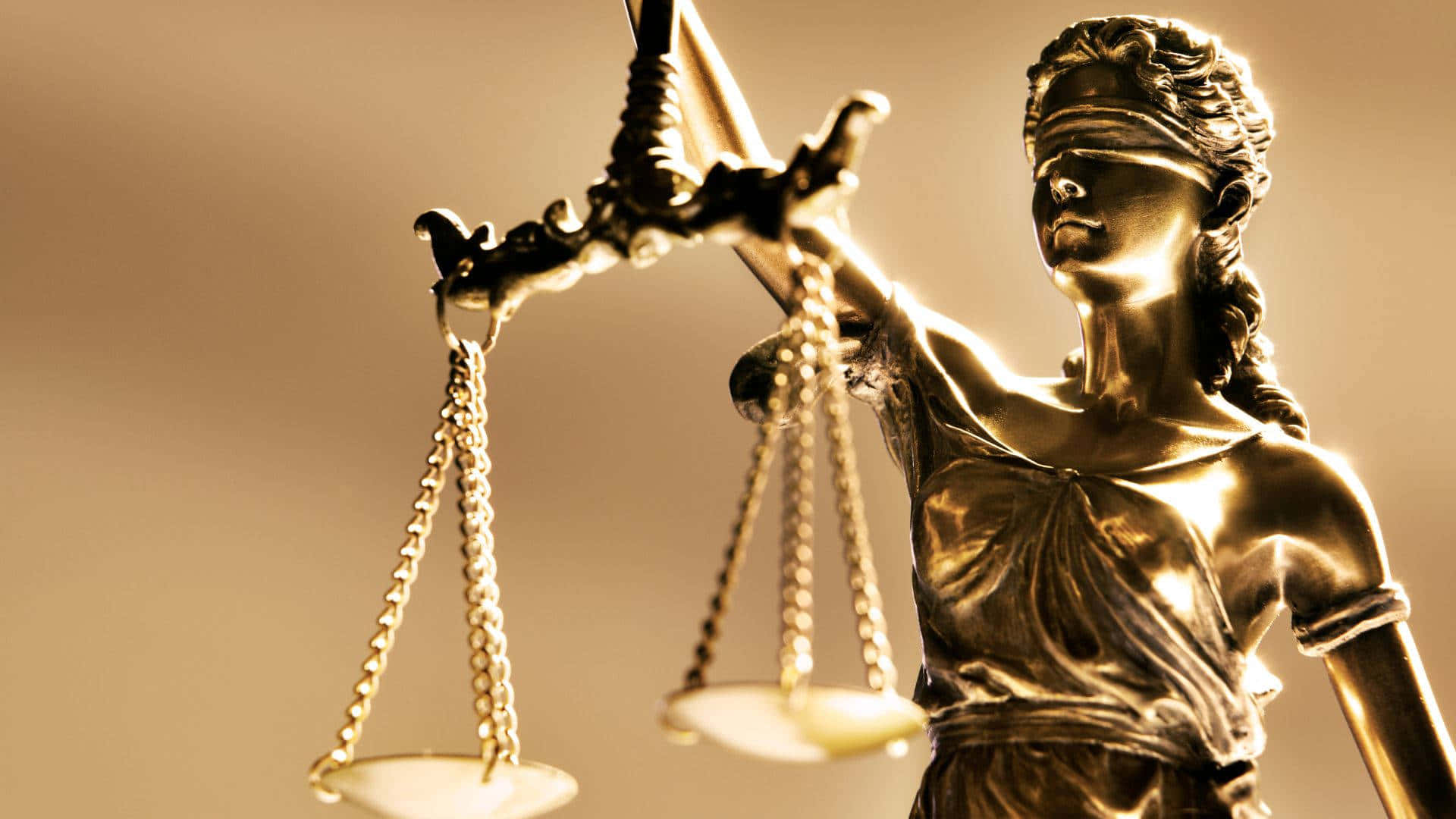 Justice 桌布 壁紙 — 正義女神金色雕像，在溫暖燈光下蒙眼手持平衡天秤。