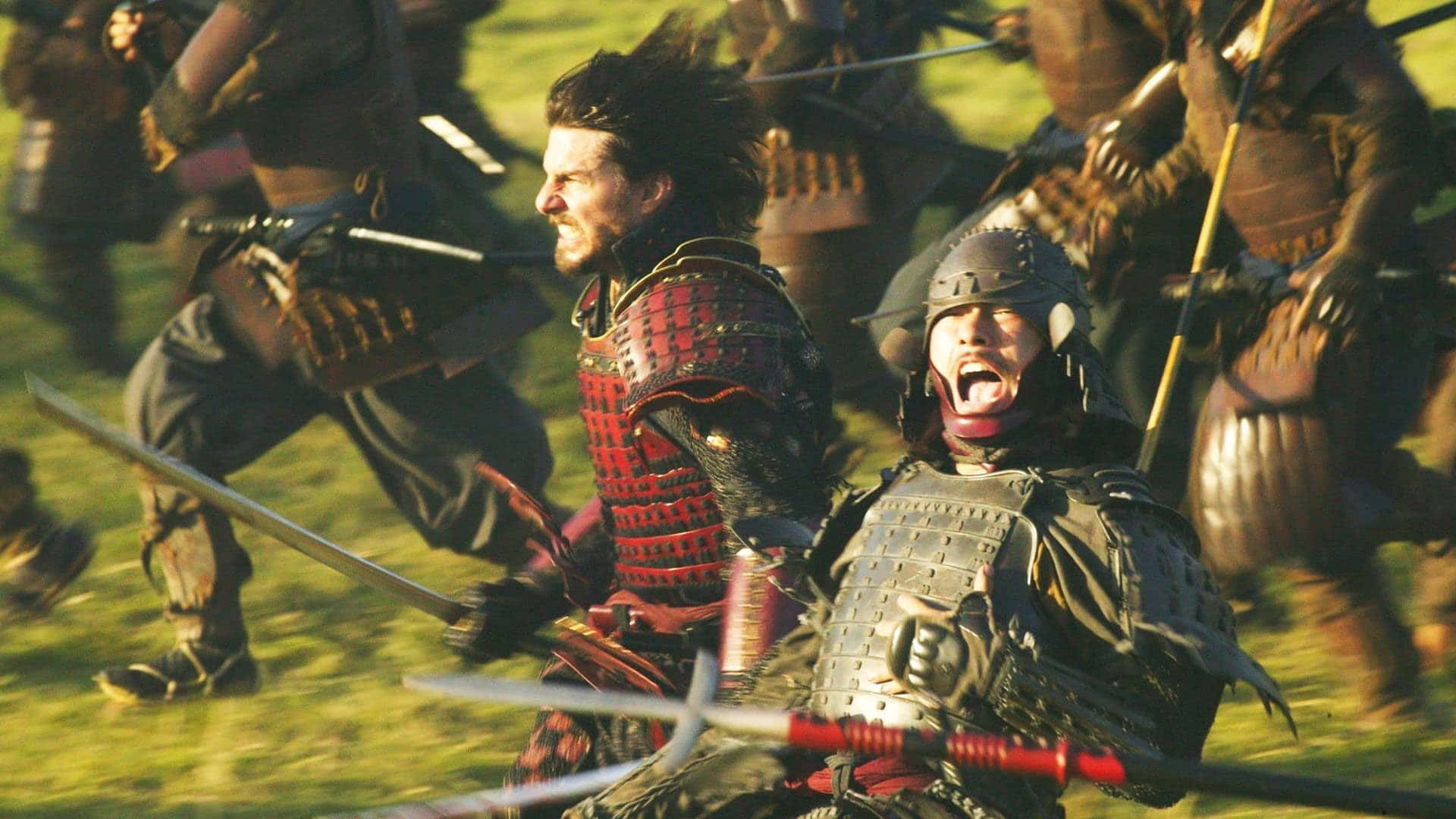 Samurai Movies 桌布 壁紙 — 武士武士喺混亂嘅中世紀戰場上衝突，拔出劍，表情激烈，喺金色陽光下。