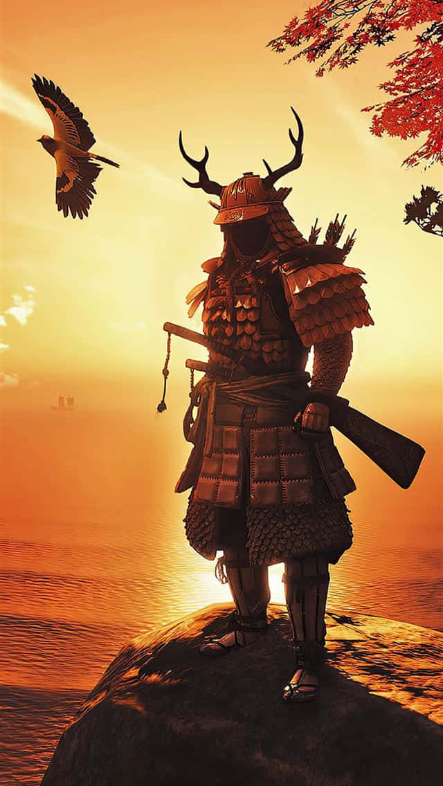 武士的旅程——《對馬島之鬼》現已登陸iPhone 壁紙 — 一名身穿華麗盔甲的武士站在夕陽下的岩石上，一隻鷹在他身旁翱翔，背景是火紅色的天空。
