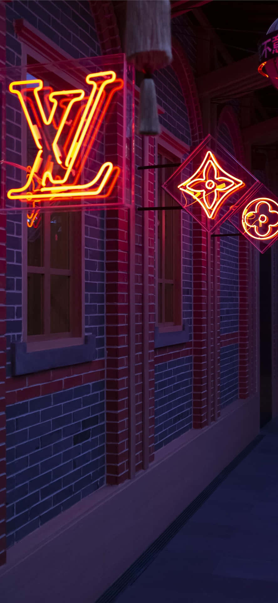 路易威登霓虹招牌在夜間照亮一座磚造建築。