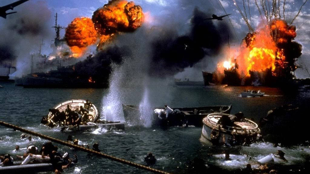 歷史性時刻：珍珠港沉沒戰艦 壁紙 — 軍艦爆炸成熾熱的橙色爆炸，水手們在煙霧和混亂中於洶湧的水域中匆忙行動。