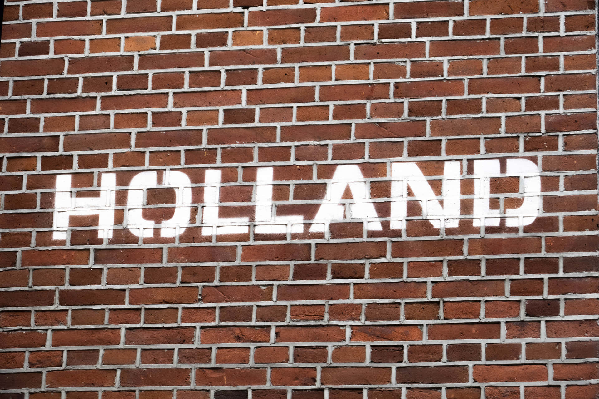 紅磚牆上的白色模板字 holland。