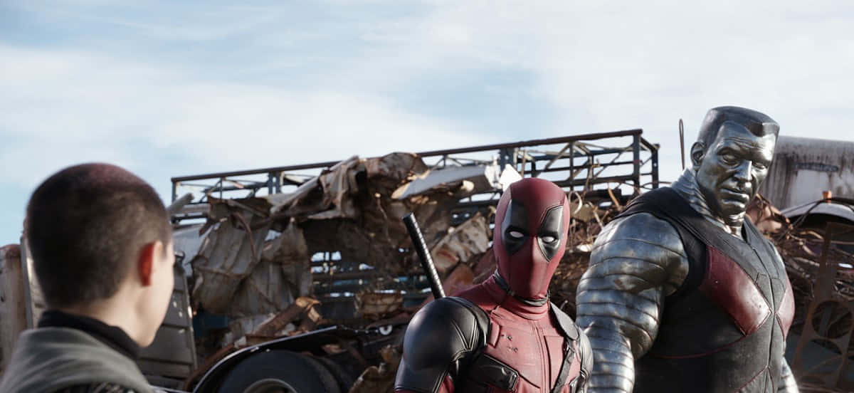 Deadpool And Colossus 桌布 壁紙 — 死侍和鋼人在垃圾場站著，一個男孩從後面看著他們。