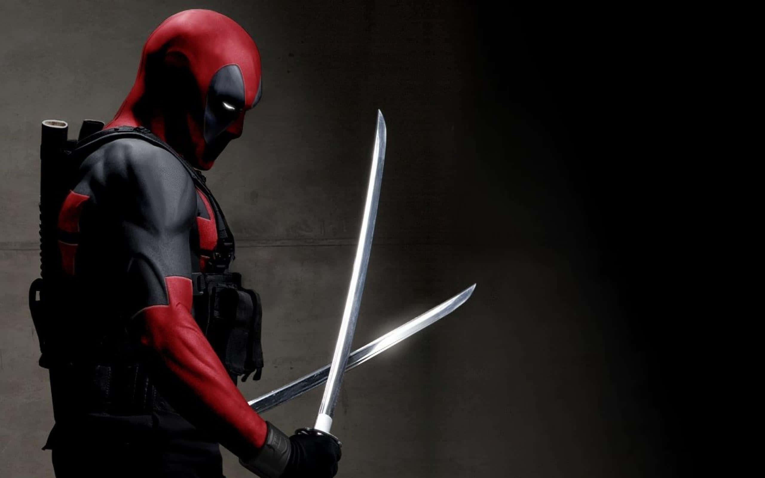 Deadpool 2 桌布 壁紙 — 死侍站在陰影混凝土中，專注地握著兩把閃亮的劍。