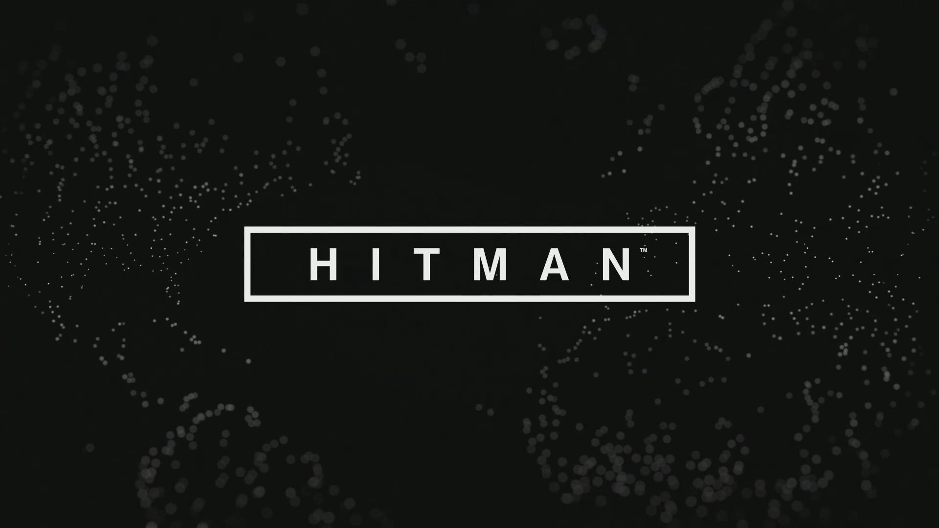 殺手標題標誌 壁紙 — 單詞 HITMAN 以粗體白色字母顯示在矩形內，背景為黑色，帶有散落的發光粒子。