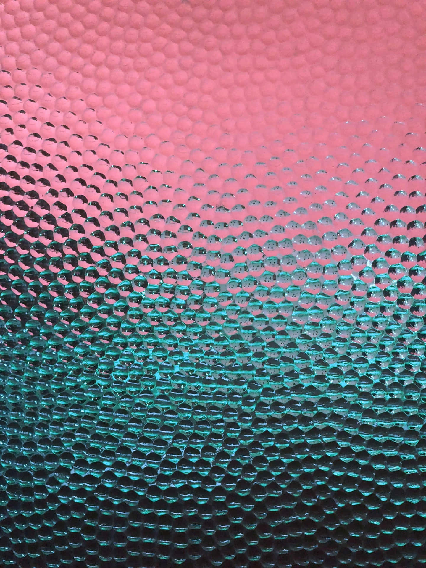 從粉紅色到藍綠色的漸變紋理，帶有氣泡狀表面圖案。