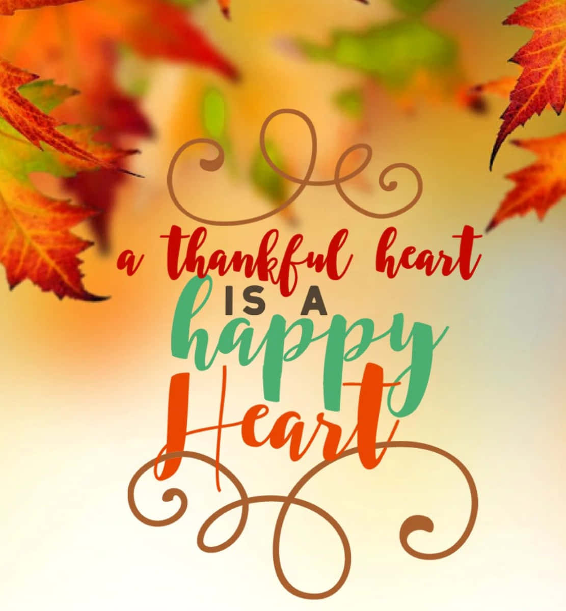 每日感恩 壁紙 — 鮮豔的秋葉框住了優雅的手寫文字，上面寫著「a thankful heart is a happy heart」，背景是溫暖的漸變色。