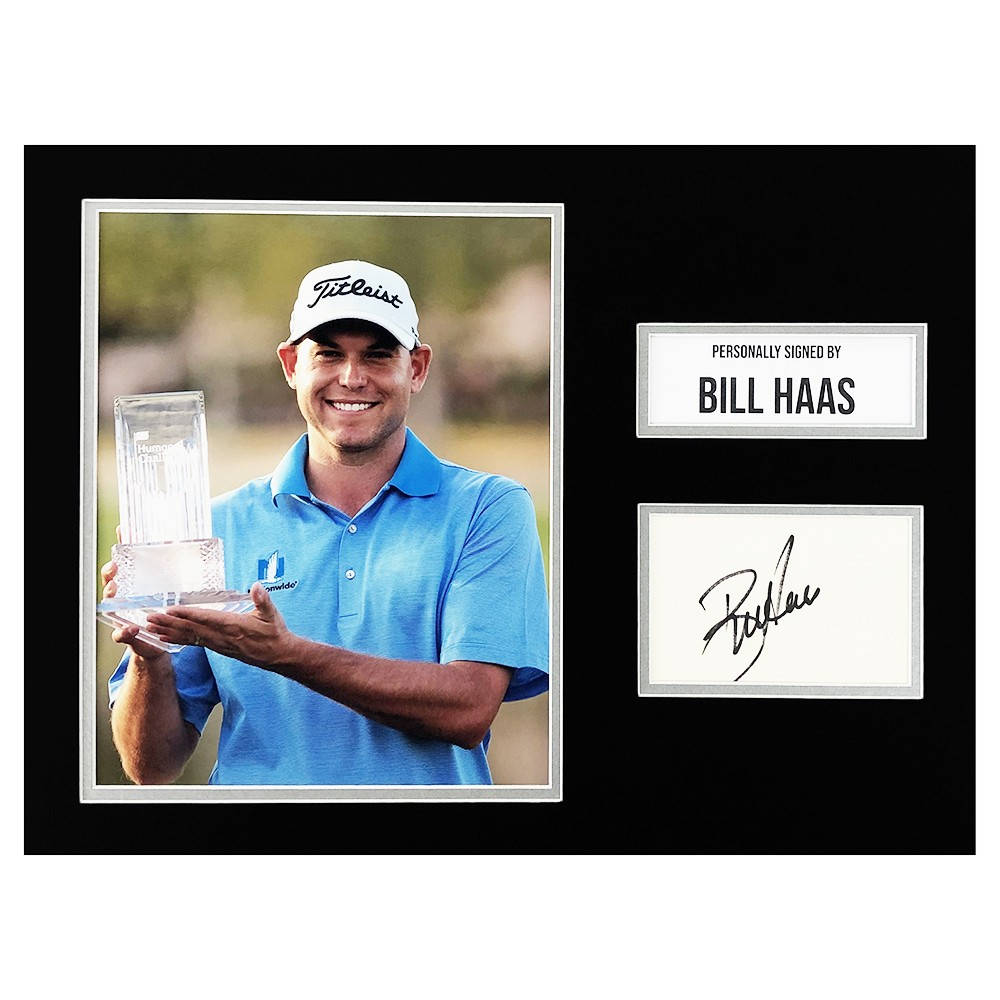 比爾·哈斯手持獎盃 壁紙 — 高爾夫球手 Bill Haas 自豪地微笑，手持水晶獎盃，旁邊放著他的親筆簽名牌。