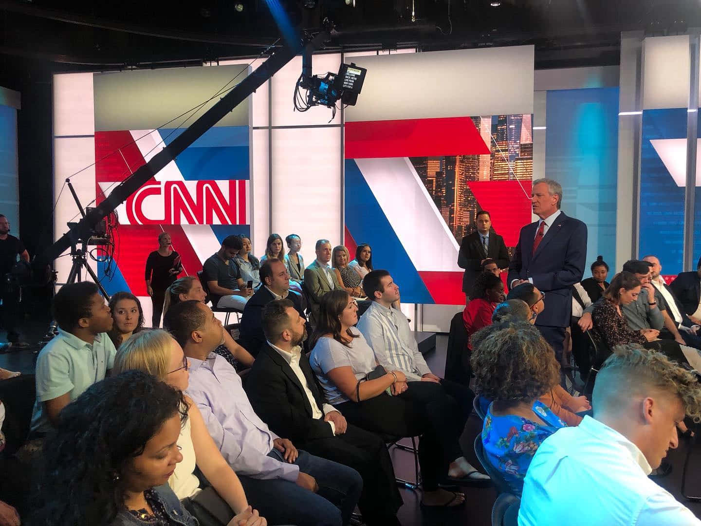 CNN錄影棚觀眾觀看一名身穿西裝的男子發言。