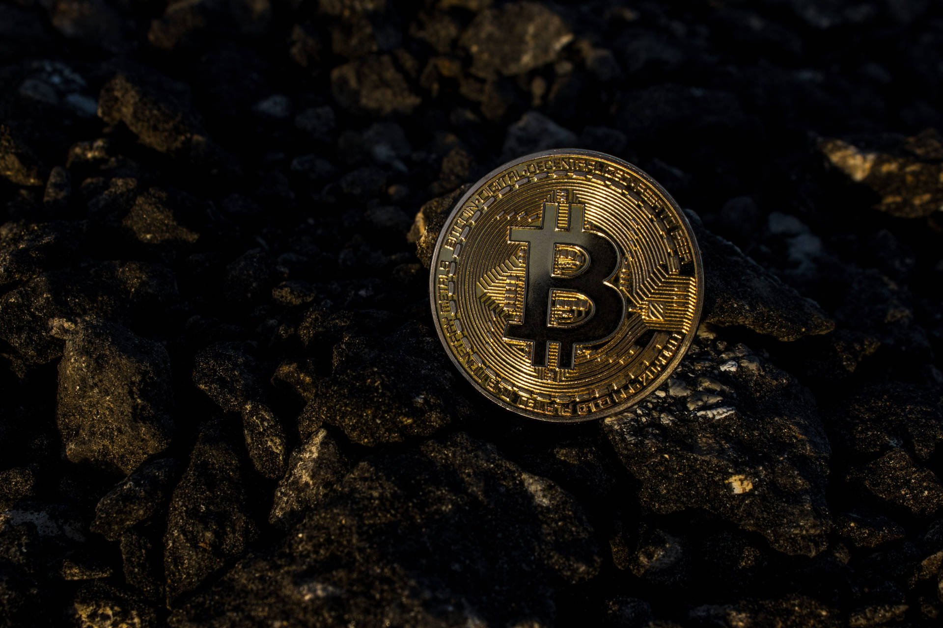 黑暗岩石表面上的金色比特幣硬幣