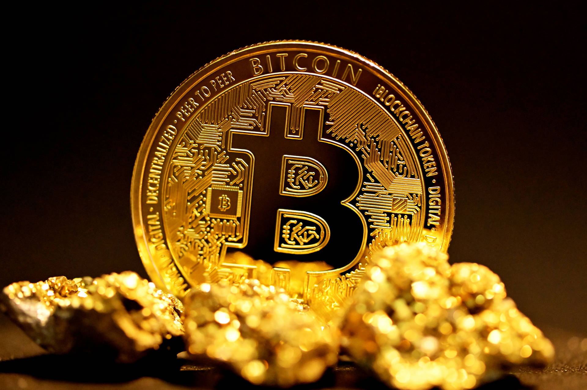 一枚金色比特幣硬幣被金塊包圍在黑暗表面上。