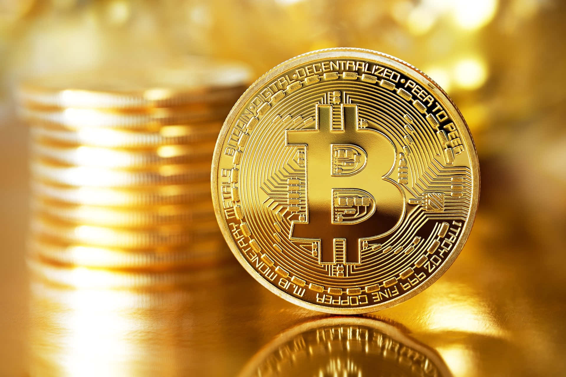 一枚閃閃發光的金色比特幣硬幣，背景有一堆模糊的硬幣。