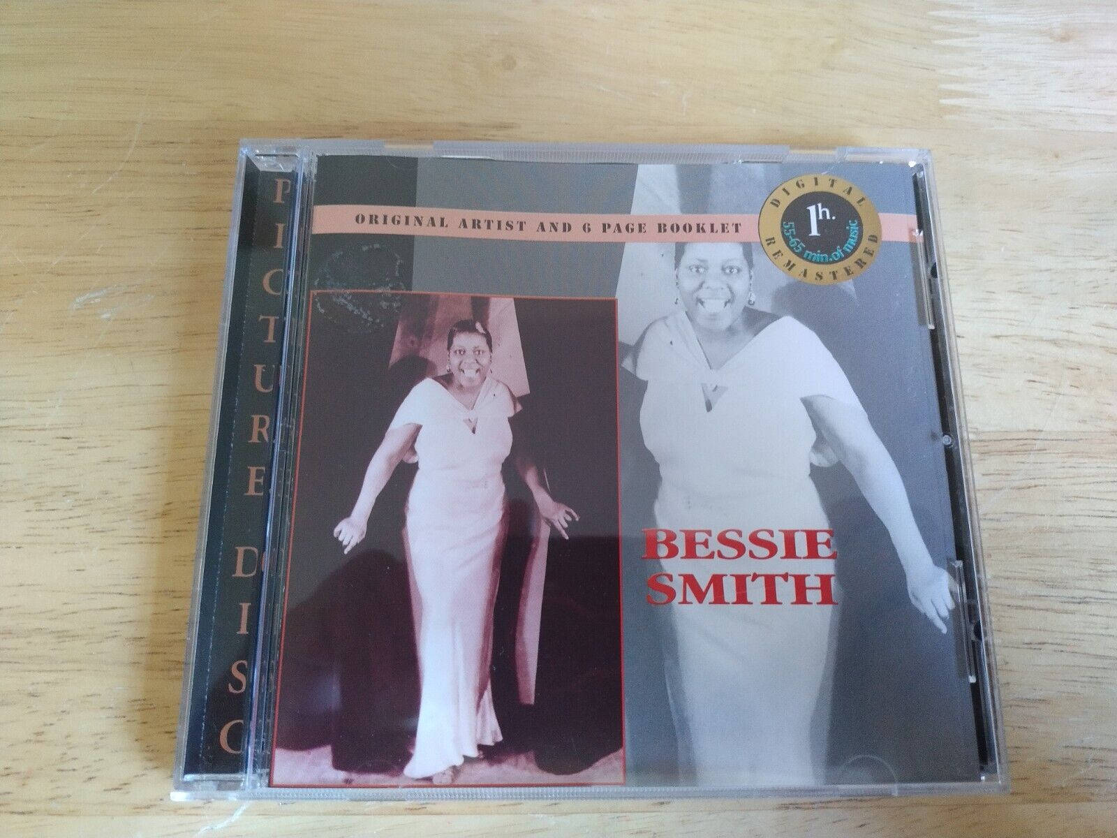比茜·史密斯專輯封面 壁紙 — 一個復古的Bessie Smith圖案光碟CD盒放在淺色木質表面上，展示了歌手兩張棕褐色調的肖像。