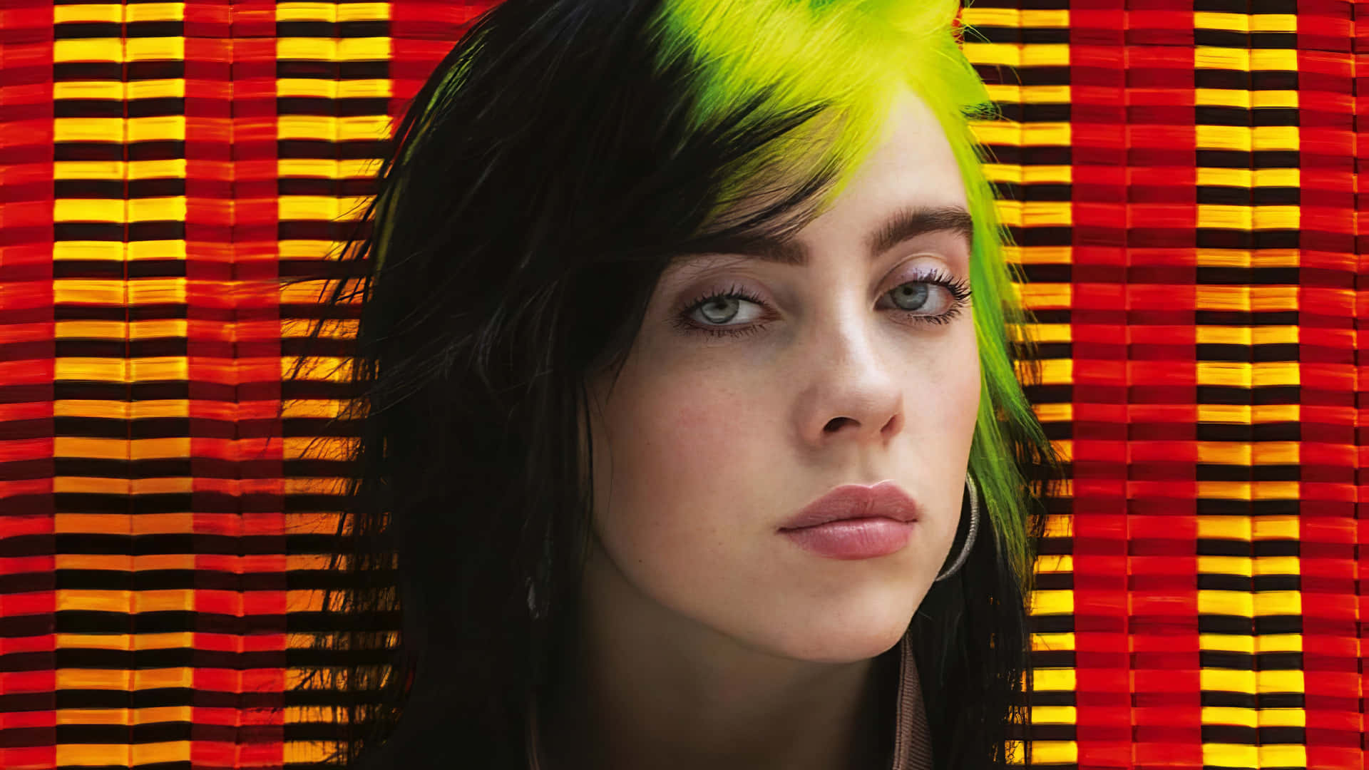 Billie Eilish 擁有螢光綠色頭髮，背景為紅黃條紋。