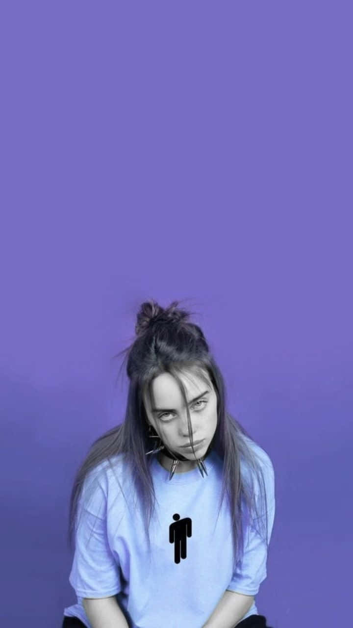 一位年輕女子，身穿淺藍色T恤，上面有黑色火柴人圖案，背景為紫色。