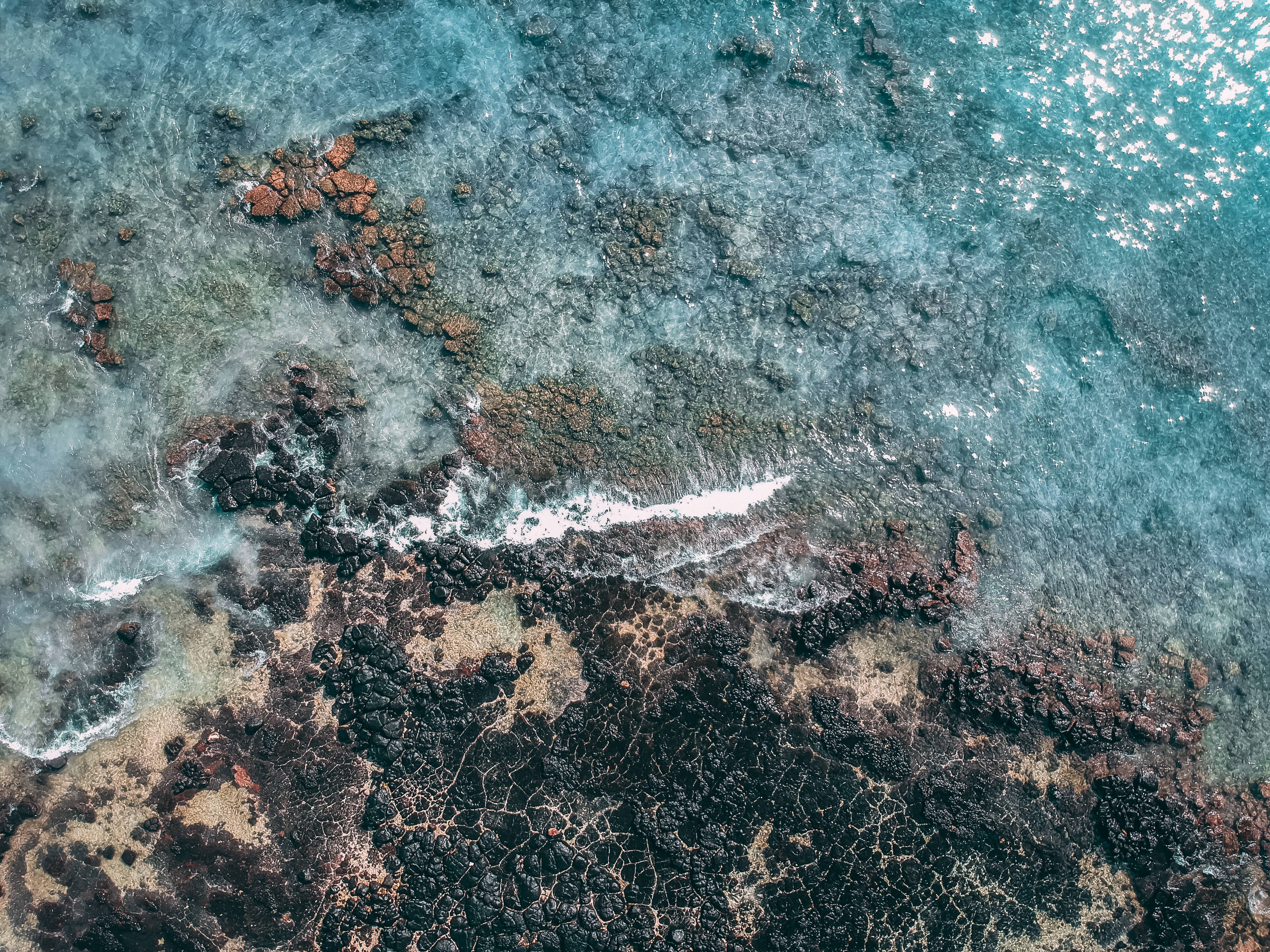毛里求斯島海邊礁石 壁紙 — 俯瞰圖：碧綠海洋波浪拍打崎嶇深色火山岩。