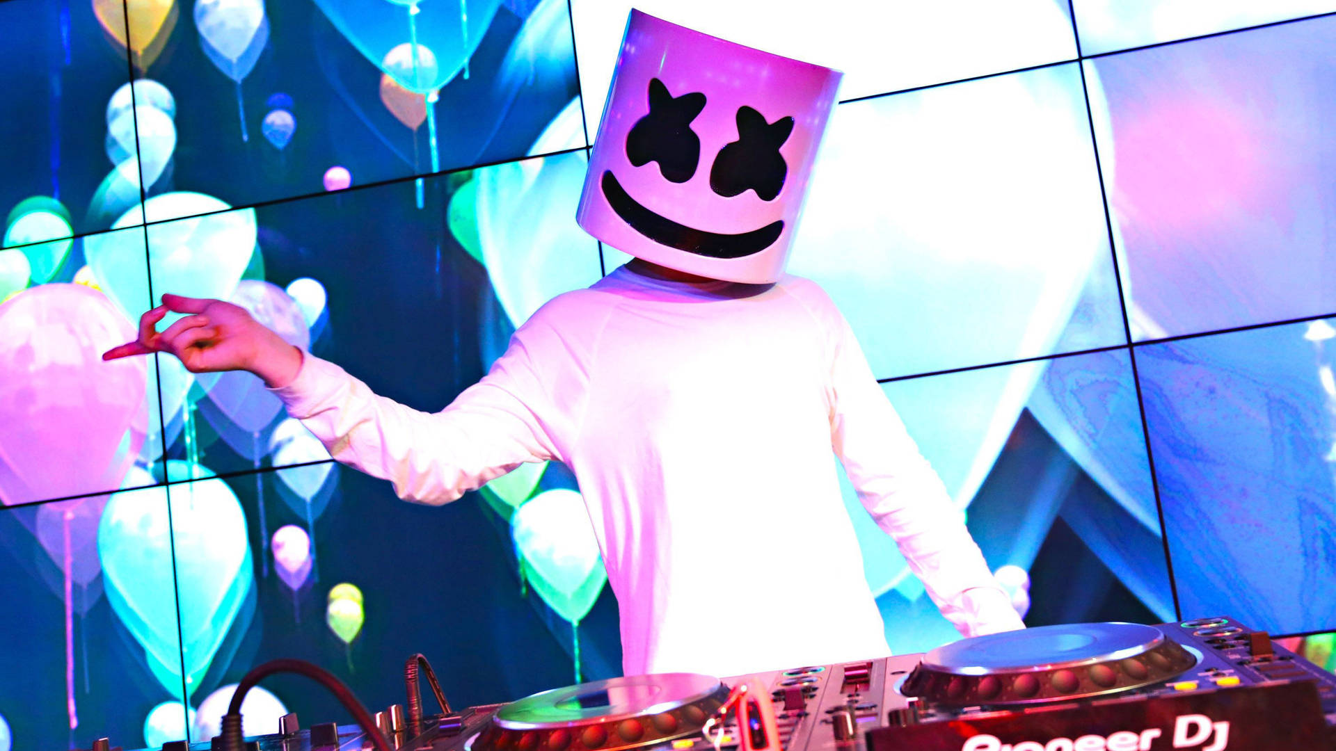 DJ Marshmello 在夜總會表演，身後有發光的氣球視覺效果。