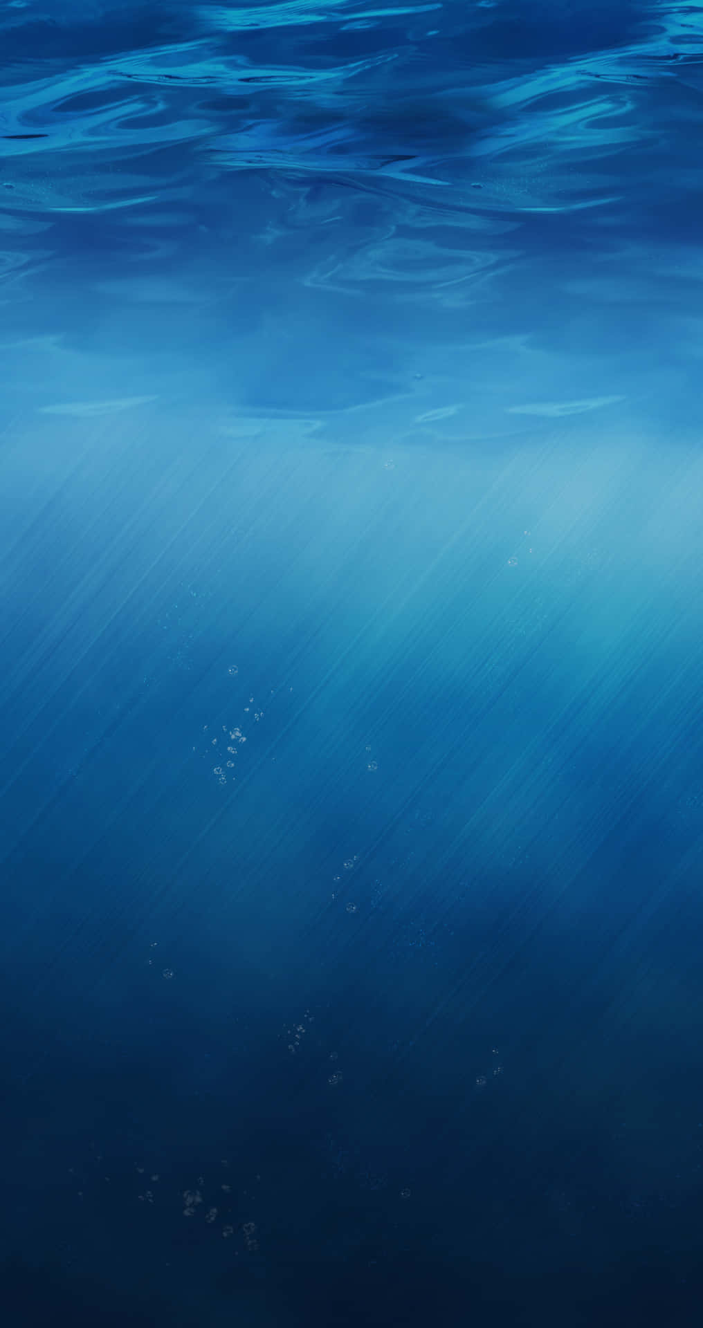 陽光穿過海面，在深藍色海水中帶有浮動的氣泡。