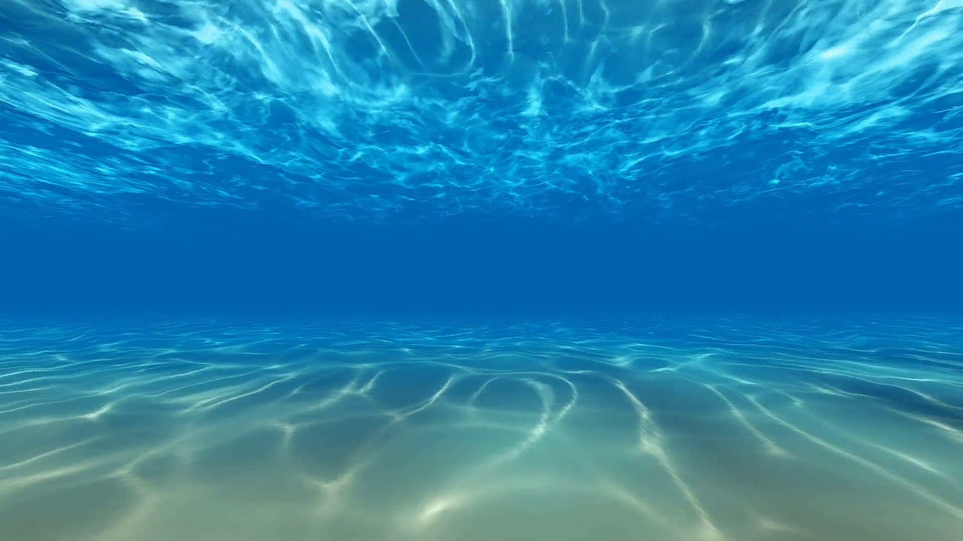 水下世界的絕美風景 壁紙 — 陽光在清澈的藍色海床上泛起漣漪，沙質海底和閃爍的海面波浪。
