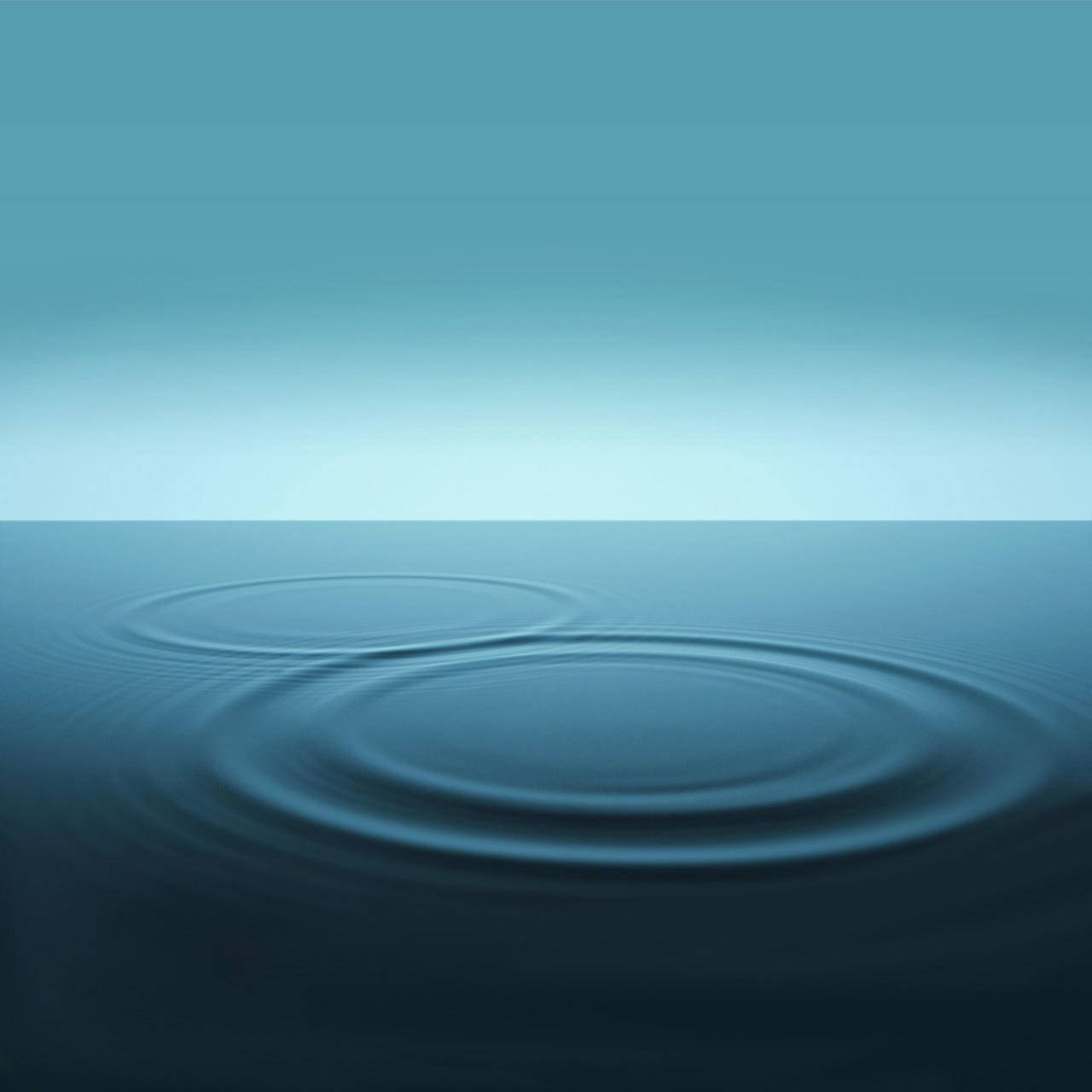 柔和漸變天空下平靜藍色水面上的漣漪