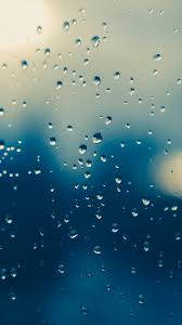 玻璃上的雨滴，背景是柔和藍天和陽光