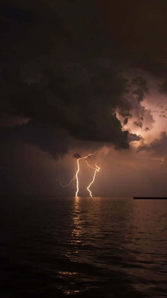 暴風夜空下黑暗海面上的閃電