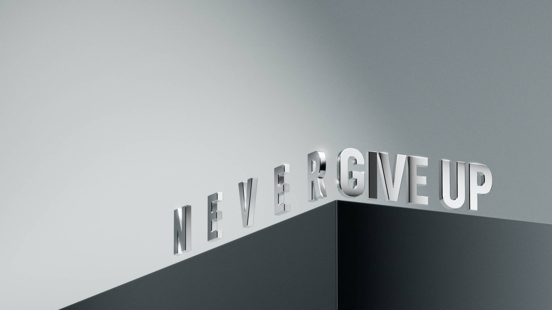 灰色牆上以金屬字母呈現的勵志短語never give up。