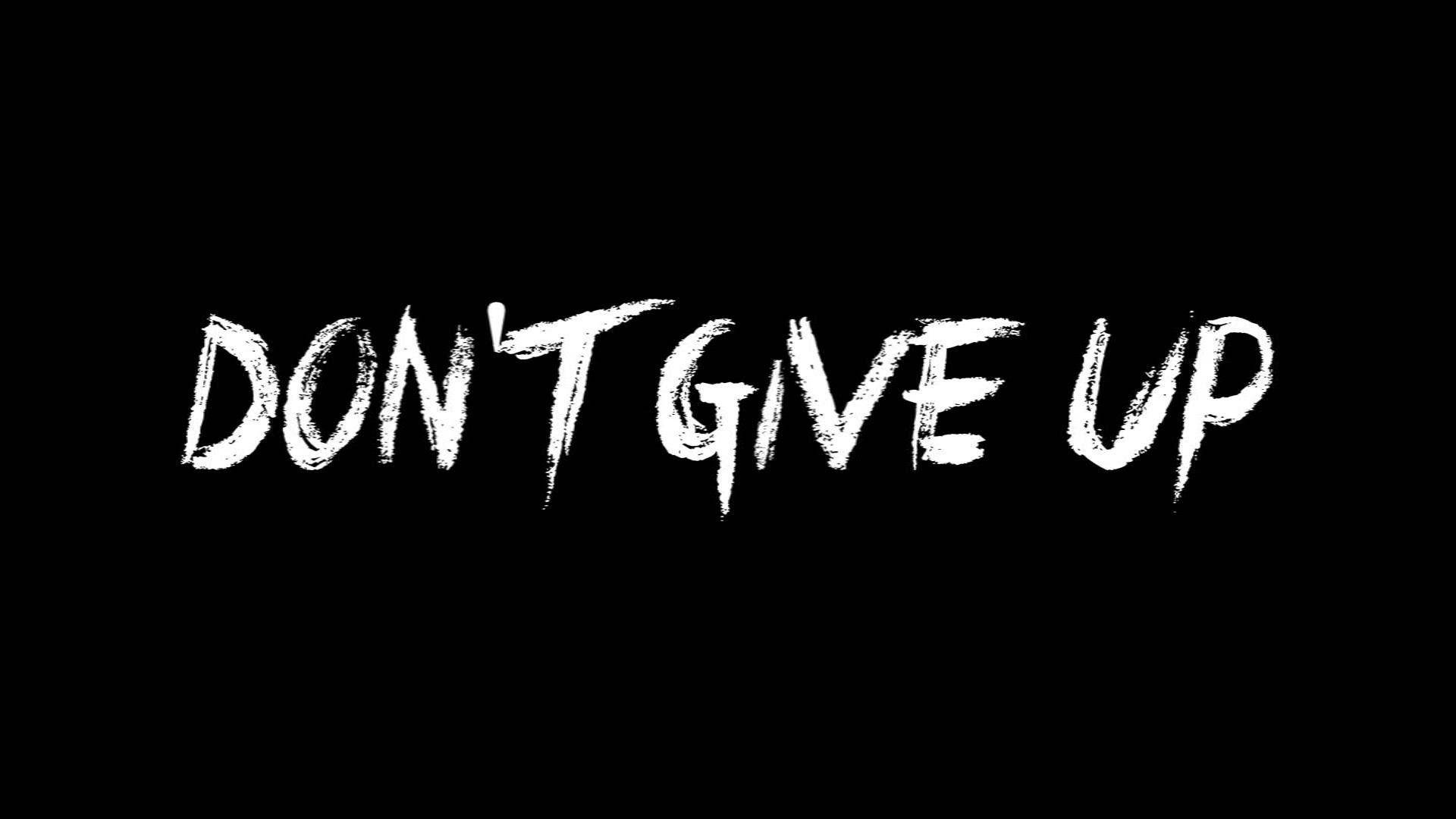 黑色背景上以粗體白色塗鴉文字呈現的勵志名言 don't give up