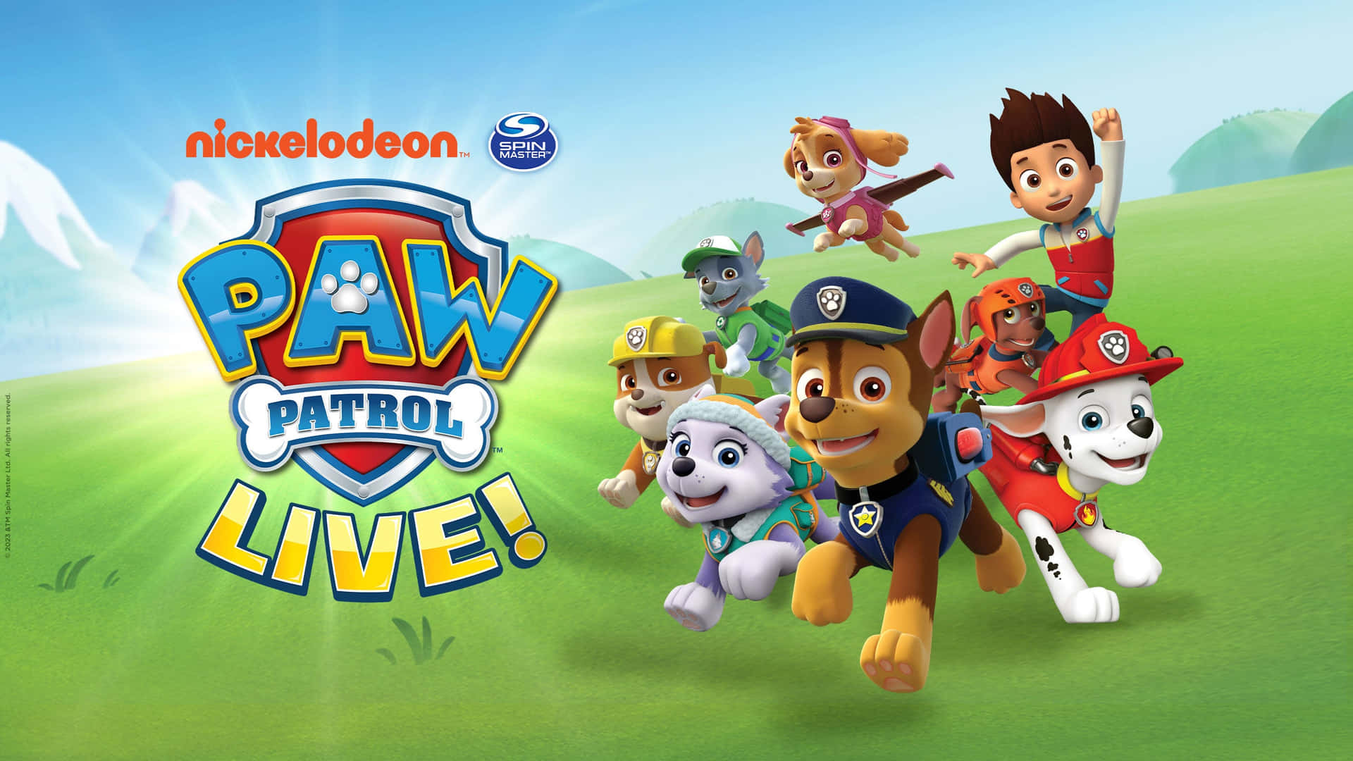 Paw Patrol 團隊喺有山脈背景嘅草地上奔跑。