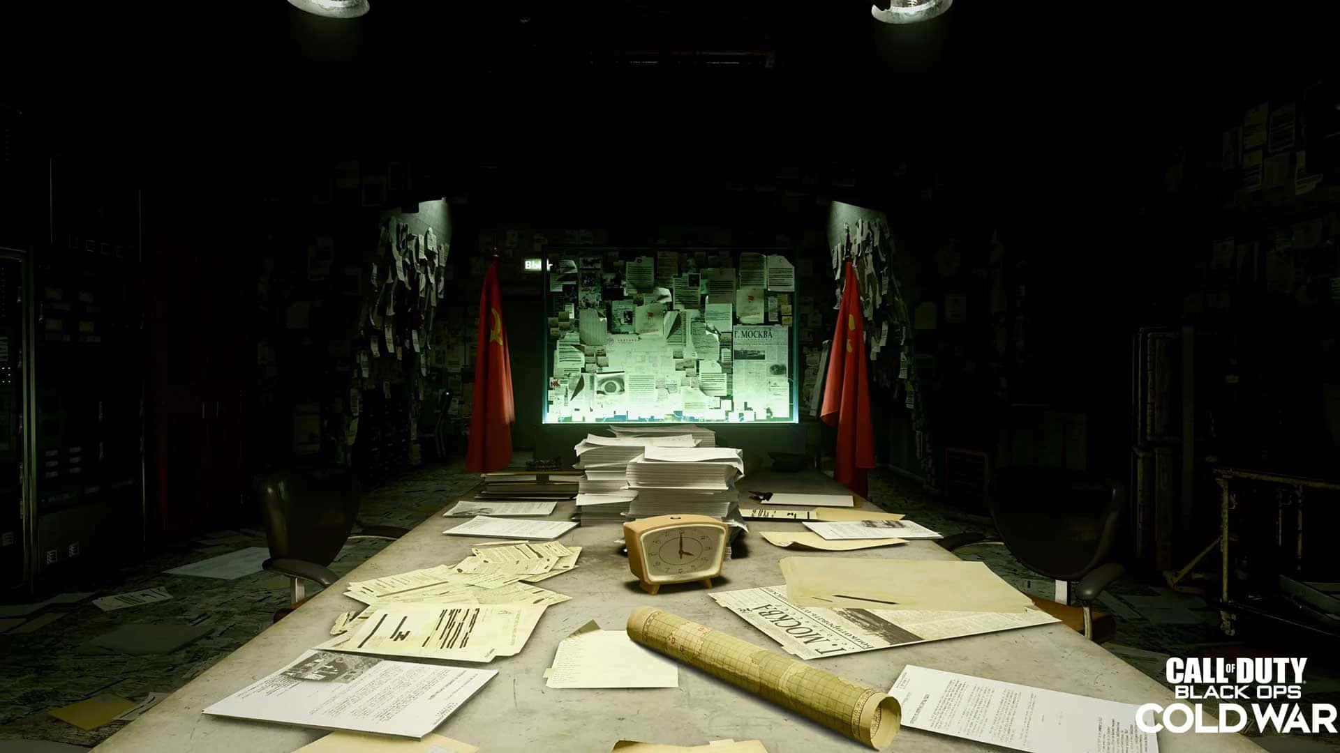 《決勝時刻：黑色行動冷戰》劇情場景截圖 壁紙 — 燈光昏暗的間諜辦公室，雜亂的辦公桌、發光的佈告欄和紅色旗幟，在刺眼的頭頂燈光下。