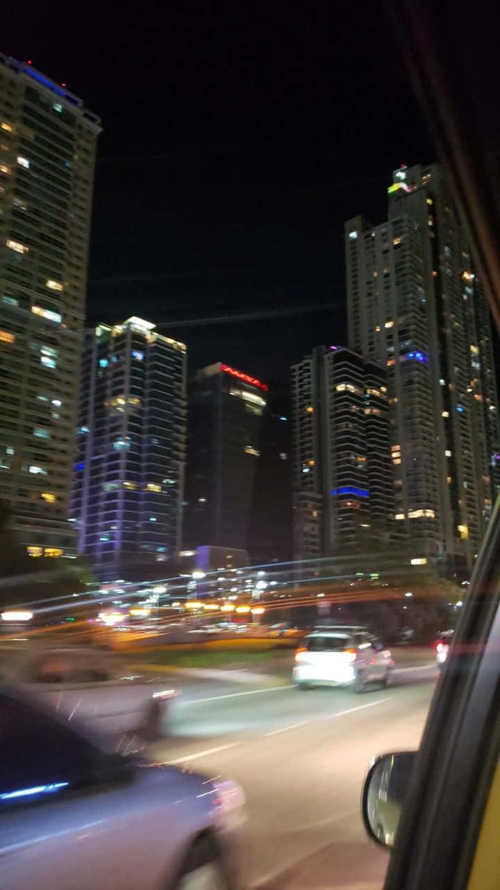 夜間駕車穿過城市，有模糊的光線和高樓大廈。