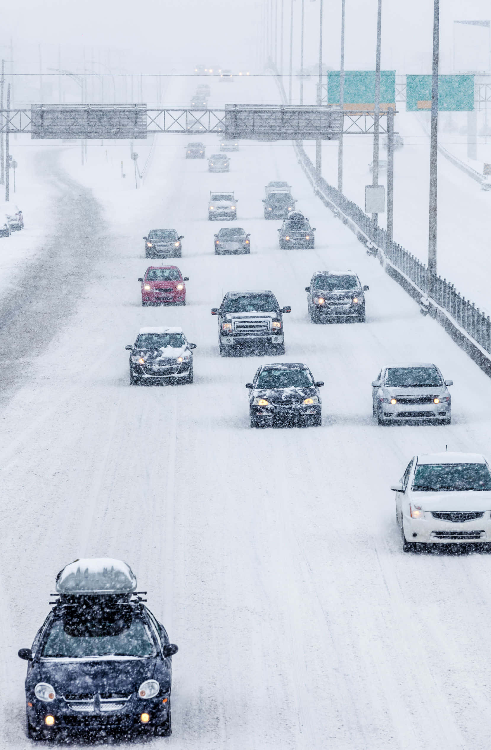 汽車駛過雪景冬季風光 壁紙 — 積雪的高速公路上，汽車在陰天大雪中謹慎行駛。