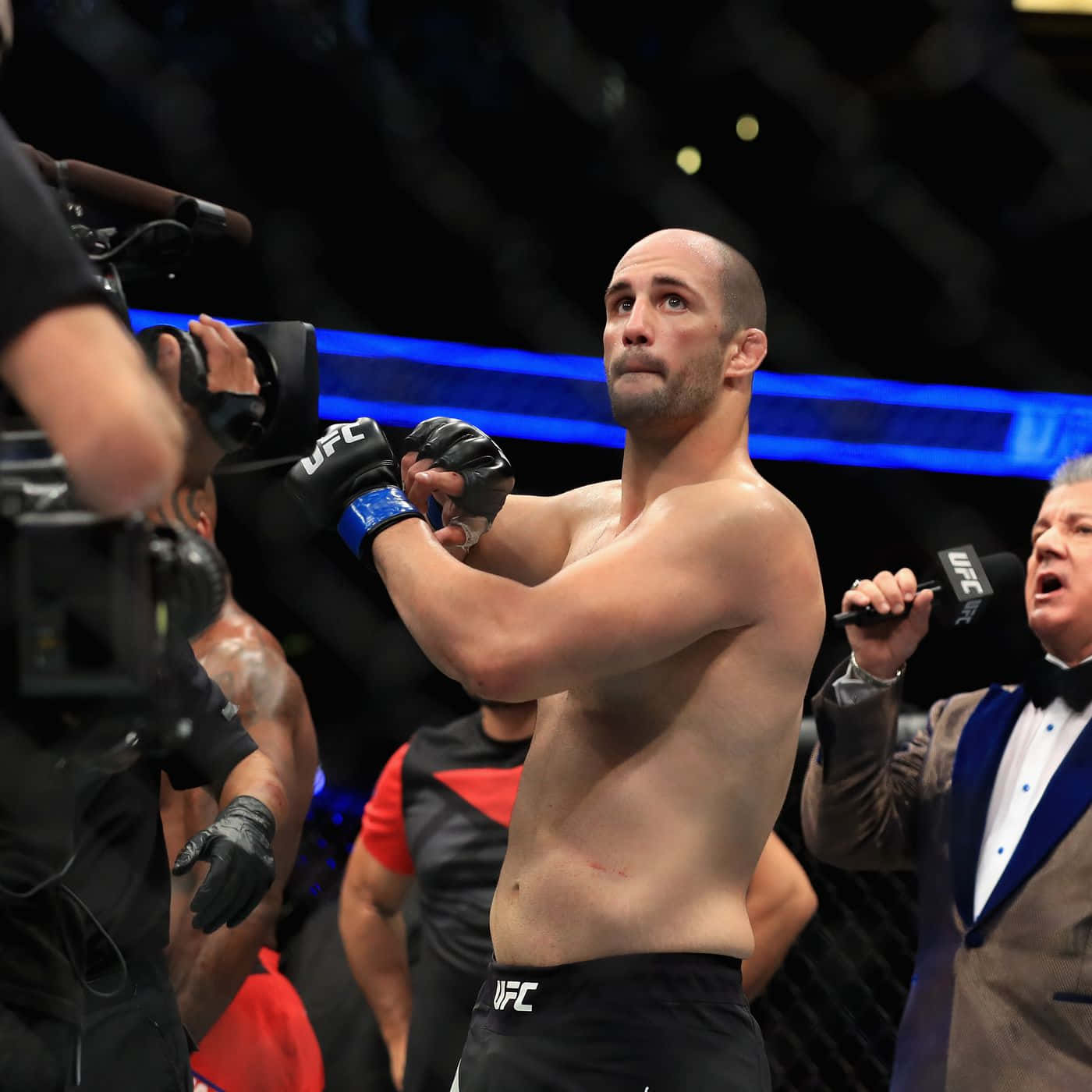 UFC拳手在八角籠內舉起雙臂慶祝勝利。