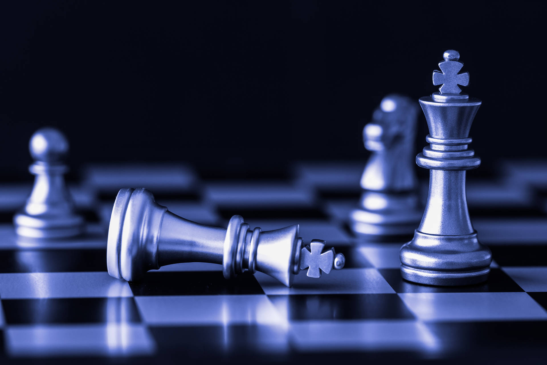 銀色國際象棋王倒在棋盤上，另一個直立。
