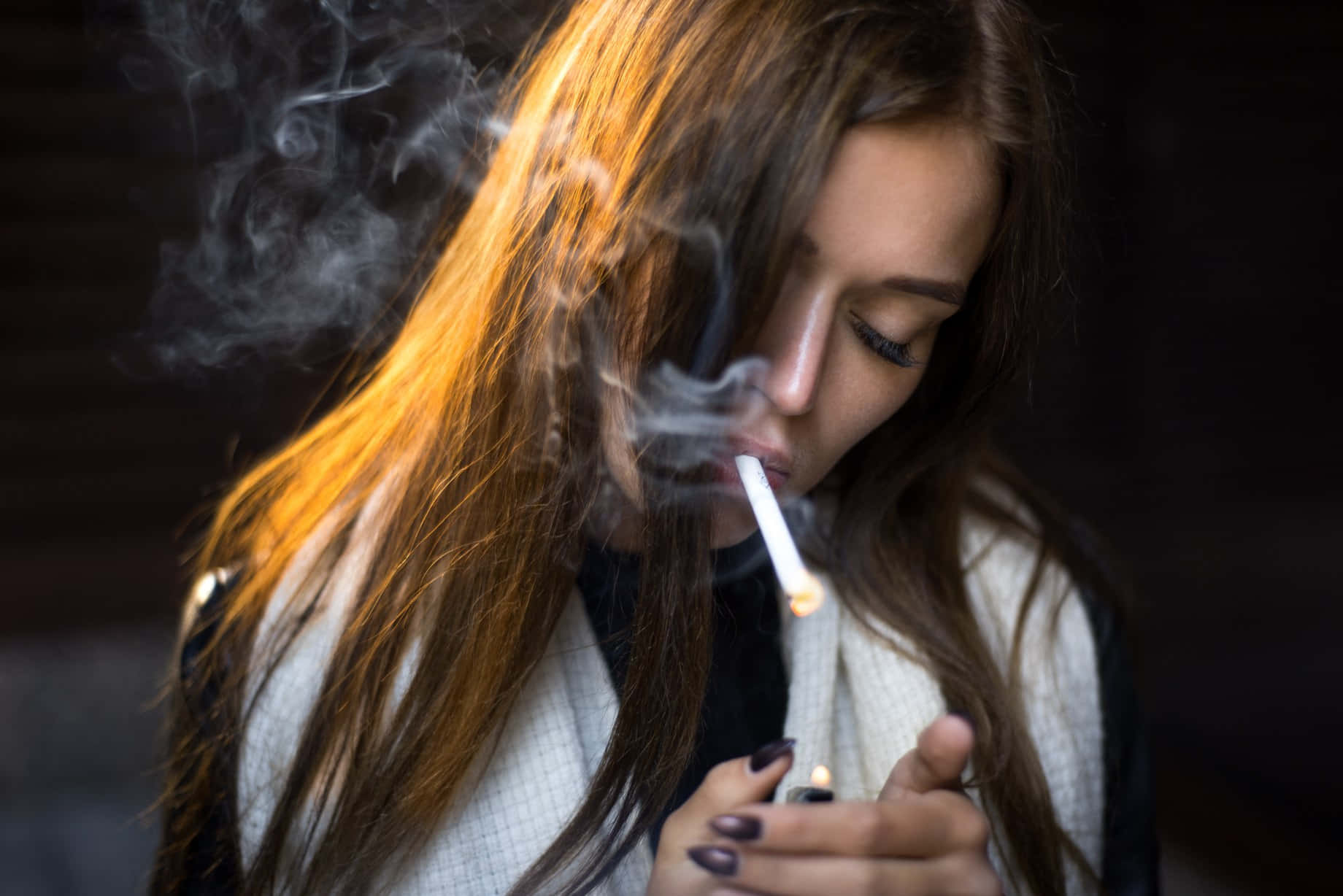 女性抽煙，煙霧在金色光線中升起