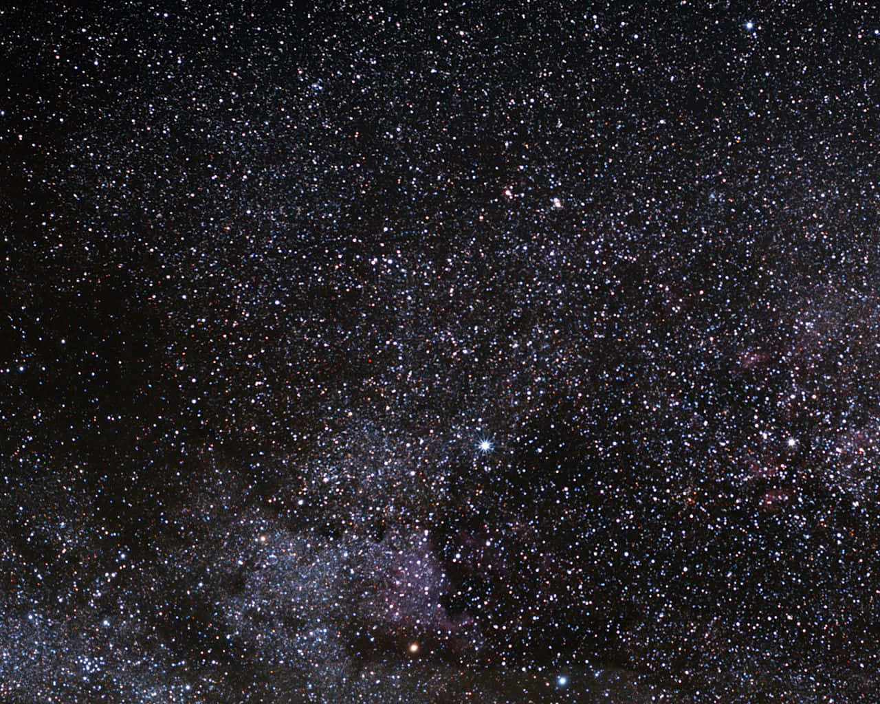 夜空中擁有密集星場和發光星雲的銀河系。