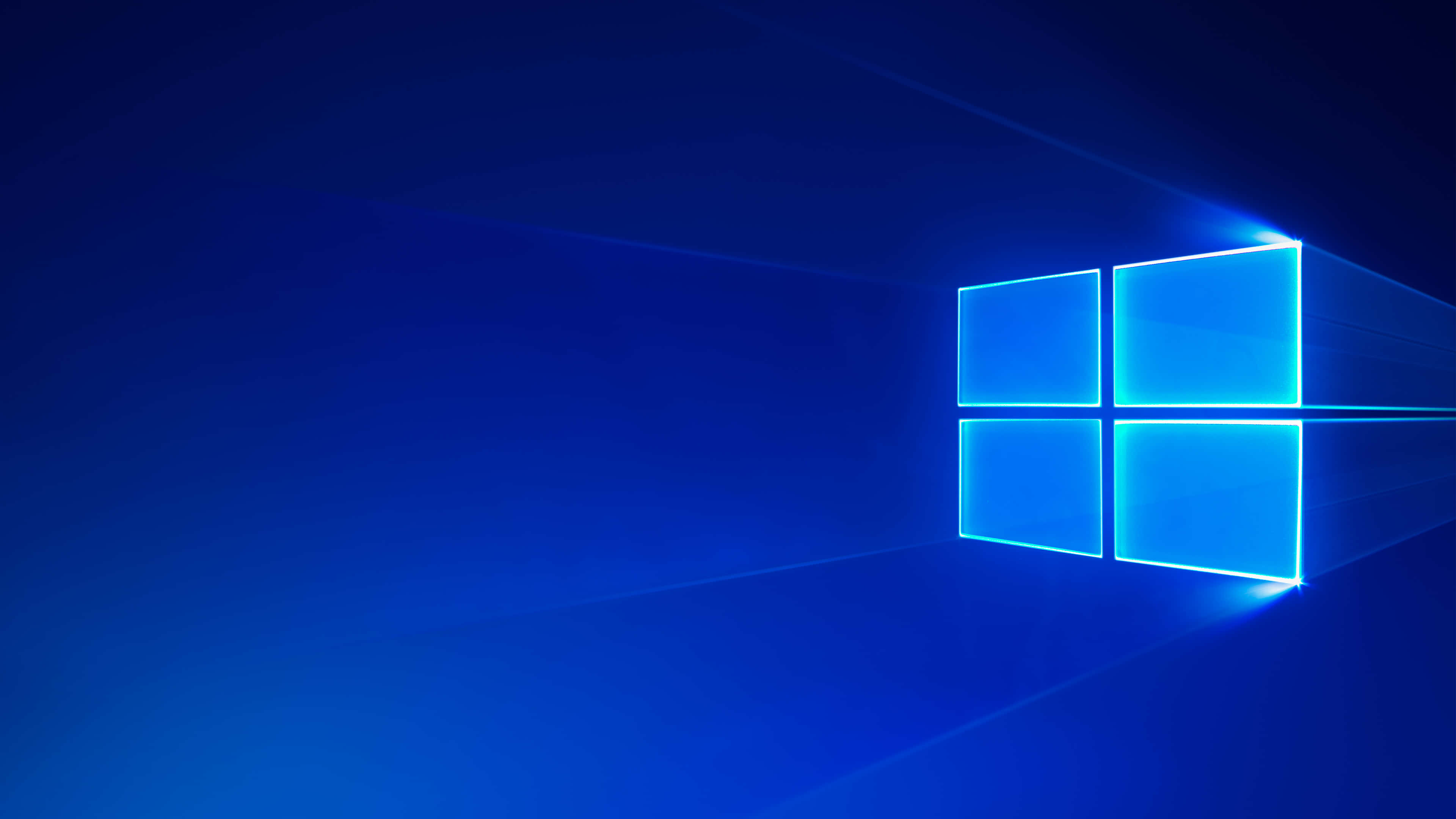 沉浸於 Windows 10 的先進功能 壁紙 — 發光的藍色Windows標誌在深藍色漸變背景上明亮閃耀，邊緣散發出光線。