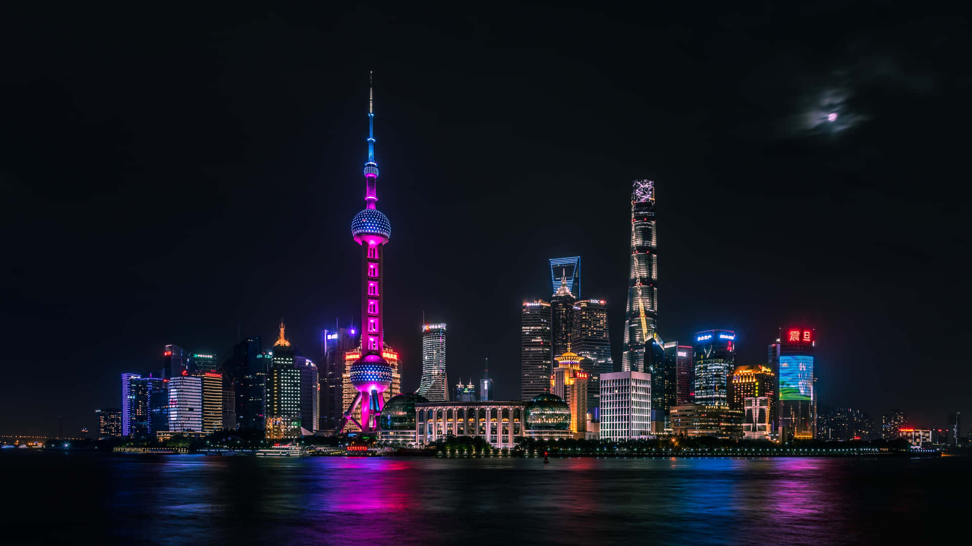 月光下上海夜景天際線，彩色燈光倒映在水面上。